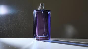 perfume rociar en un Violeta botella en un oscuro antecedentes. foto