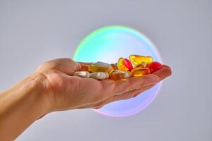 Vitamins and dietary supplements on the palm against the luminous circle. photo