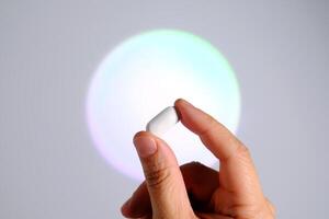 Tablet in hand against the background of a glowing circle. photo