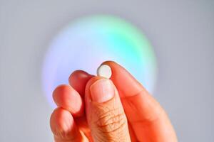 Tablet in hand against the background of a glowing circle. photo