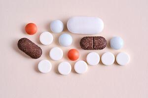 Pills, vitamins and dietary supplements on a beige background. photo