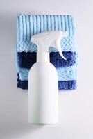 Cleaning product with a sprayer on a background of a blue microfiber cloth. photo