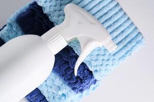 Cleaning product with a sprayer on a background of a blue microfiber cloth. photo