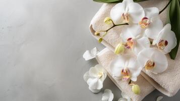 Serene Spa Concept with White Orchids and Soft Towels on Textured Background. photo