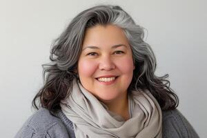 Portrait of a cheerful mature woman with silver hair and a warm scarf. photo