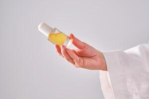 Blue serum with pipette in a womans hands in a robe. photo