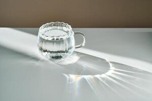 A glass of clean drinking water in the morning sun. photo