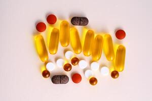 Pills, vitamins and dietary supplements on a beige background. photo