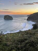 Oceanfront at San Juan de Gaztelugatxe in Spain during sunrise photo