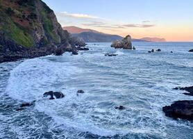 Oceanfront at San Juan de Gaztelugatxe in Spain during sunrise photo