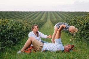 Happy family with little daughter spending time together in sunny field. photo