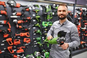 a buyer in a hardware store walks between with a power tool photo