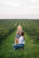 Stilish mother and daughter having fun on the nature. Happy family concept. Beauty nature scene with family outdoor lifestyle. Happy family resting together. Happiness in family life. Mothers day photo