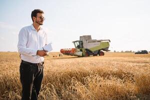 contento granjero en el campo comprobación maíz plantas durante un soleado verano día, agricultura y comida producción concepto. foto