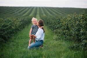 Stilish mother and daughter having fun on the nature. Happy family concept. Beauty nature scene with family outdoor lifestyle. Happy family resting together. Happiness in family life. Mothers day photo