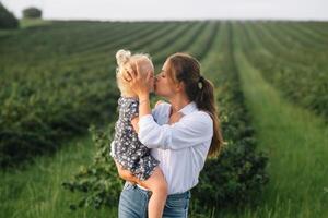 elegante madre y hija teniendo divertido en el naturaleza. contento familia concepto. belleza naturaleza escena con familia al aire libre estilo de vida. contento familia descansando juntos. felicidad en familia vida. madres día foto