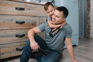 Young man and his son with oven sheet in kitchen. Father with little son on the kitchen photo