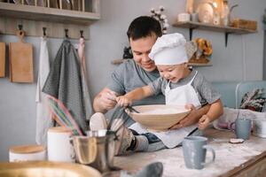 Young man and his son with oven sheet in kitchen. Father with little son on the kitchen. photo