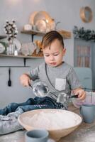 Young boy cute on the kitchen cook chef in white uniform and hat near table. homemade gingerbread. the boy cooked the chocolate cookies. photo