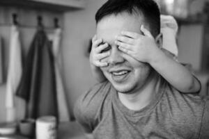 joven hombre y su hijo con horno sábana en cocina. padre con pequeño hijo en el cocina. foto