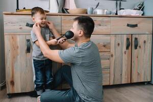 Young man and his son with oven sheet in kitchen. Father with little son on the kitchen photo