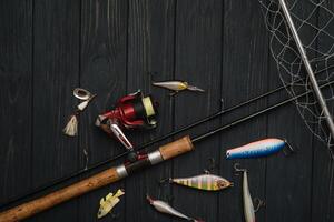 pescar entrada - pescar hilado, manos y señuelos en oscurecer de madera antecedentes. parte superior ver foto