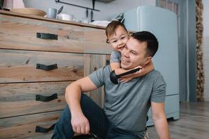 Young man and his son with oven sheet in kitchen. Father with little son on the kitchen photo