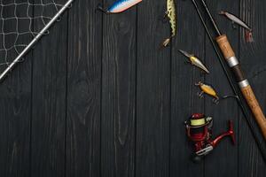 pescar entrada - pescar hilado, manos y señuelos en oscurecer de madera antecedentes. parte superior ver foto