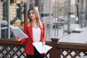 Portrait of business women in feeling of concentrate stress and see stand and hold the paper file sheet in the outdoor pedestrian walk way with the city space of exterior modern facade building photo