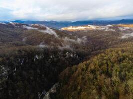 View of the autumn village in the mountains through the clouds photo