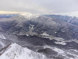 ver de el invierno puesta de sol y cubierto de nieve montañas en Sochi foto