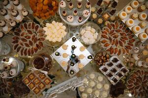 desserts with fruits, mousse, biscuits. Different types of sweet pastries, small colorful sweet cakes, macaron, and other desserts in the sweet buffet. candy bar for birthday. photo