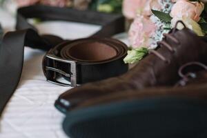 Men's leather shoes, watches and cufflinks on the background of a brown table. Clothing accessories businessman. Concept of grooms accessories at wedding day photo