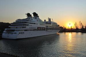 Luxury cruise ship sailing to port on sunrise. photo