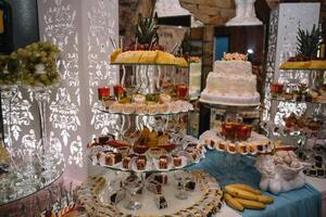 desserts with fruits, mousse, biscuits. Different types of sweet pastries, small colorful sweet cakes, macaron, and other desserts in the sweet buffet. candy bar for birthday. photo