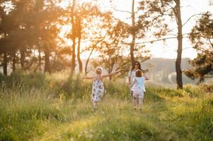 elegante madre y hermoso hija teniendo divertido en el naturaleza. contento familia concepto. belleza naturaleza escena con familia al aire libre estilo de vida. familia descansando juntos. felicidad en familia vida. madres día. foto