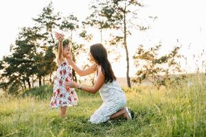 Stylish mother and handsome daughter having fun on the nature. Happy family concept. Beauty nature scene with family outdoor lifestyle. family resting together. Happiness in family life. Mothers day. photo