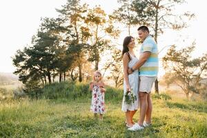 contento familia concepto - padre, madre y niño hija teniendo divertido y jugando en naturaleza foto