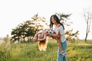 Mother and daughter having fun in the park. Happiness and harmony in family life. Beauty nature scene with family outdoor lifestyle photo