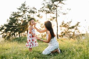 Stylish mother and handsome daughter having fun on the nature. Happy family concept. Beauty nature scene with family outdoor lifestyle. family resting together. Happiness in family life. Mothers day. photo