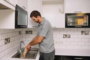 Man cutting fresh fish in kitchen in home. Man butchering fish for cook. photo