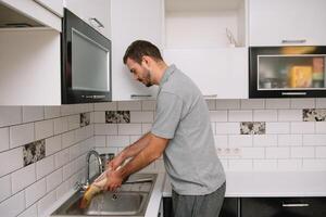 Man cutting fresh fish in kitchen in home. Man butchering fish for cook. photo