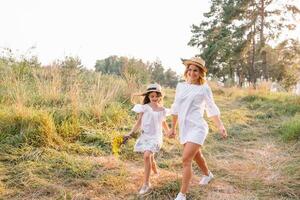 Stylish mother and handsome daughter having fun on the nature. Happy family concept. Beauty nature scene with family outdoor lifestyle. family resting together. Happiness in family life. Mothers day. photo