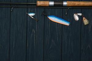 pescar entrada - pescar hilado, manos y señuelos en oscurecer de madera antecedentes. parte superior vista. foto