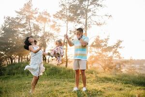 Happy family of three persons walking the grass in the park photo