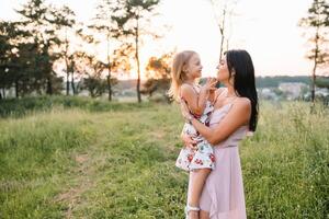 Stylish mother and handsome daughter having fun on the nature. Happy family concept. Beauty nature scene with family outdoor lifestyle. family resting together. Happiness in family life. Mothers day. photo