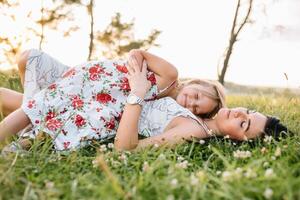 Mother and daughter having fun in the park. Happiness and harmony in family life. Beauty nature scene with family outdoor lifestyle photo