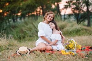 Stylish mother and handsome daughter having fun on the nature. Happy family concept. Beauty nature scene with family outdoor lifestyle. family resting together. Happiness in family life. Mothers day. photo