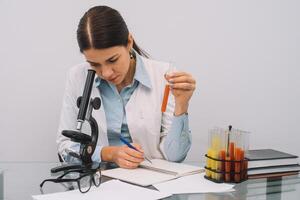 A beautiful female medical or scientific researcher using her microscope in a laboratory. photo