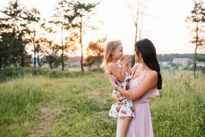 Stylish mother and handsome daughter having fun on the nature. Happy family concept. Beauty nature scene with family outdoor lifestyle. family resting together. Happiness in family life. Mothers day. photo